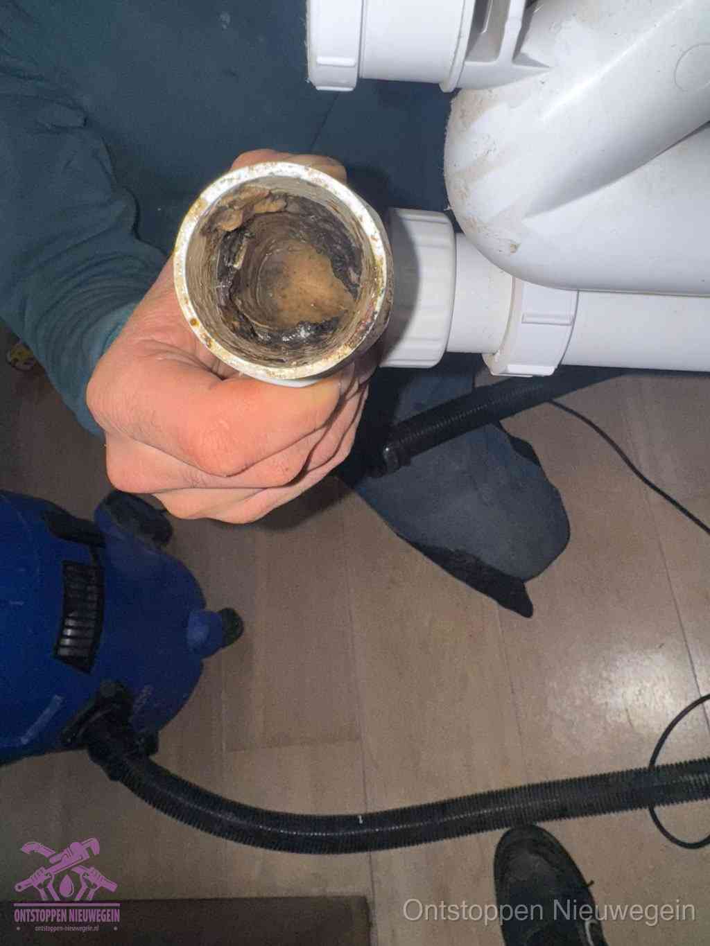 Een losgekoppeld afvoerbuisstuk dat van binnen volledig is dichtgeslibd, het gevolg van een verstopping te lang laten zitten in Nieuwegein