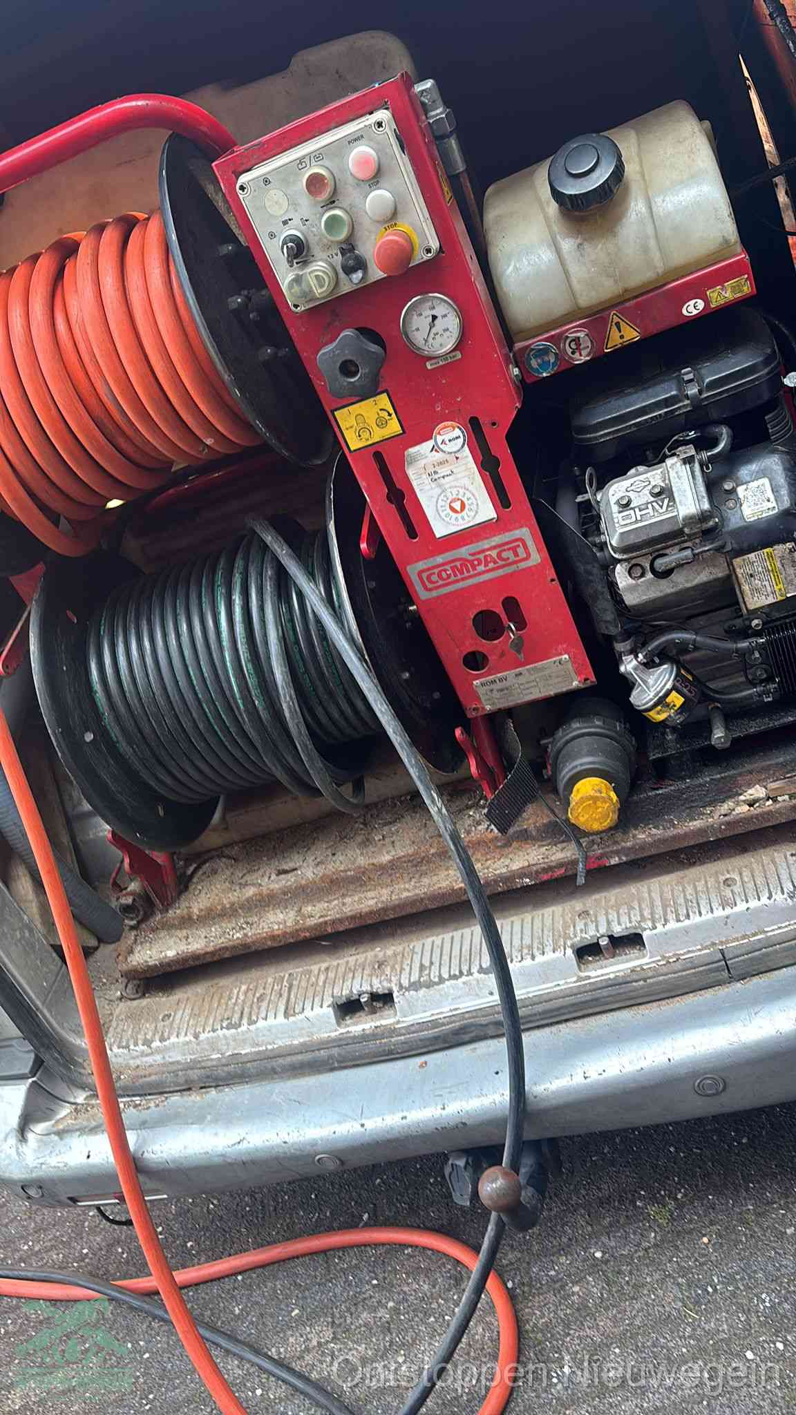 Een rood hogedruk-rioolreinigingstoestel in de laadbak van de bedrijfsbus, apparatuur voor een hardnekkige afvoerverstopping in Nieuwegein