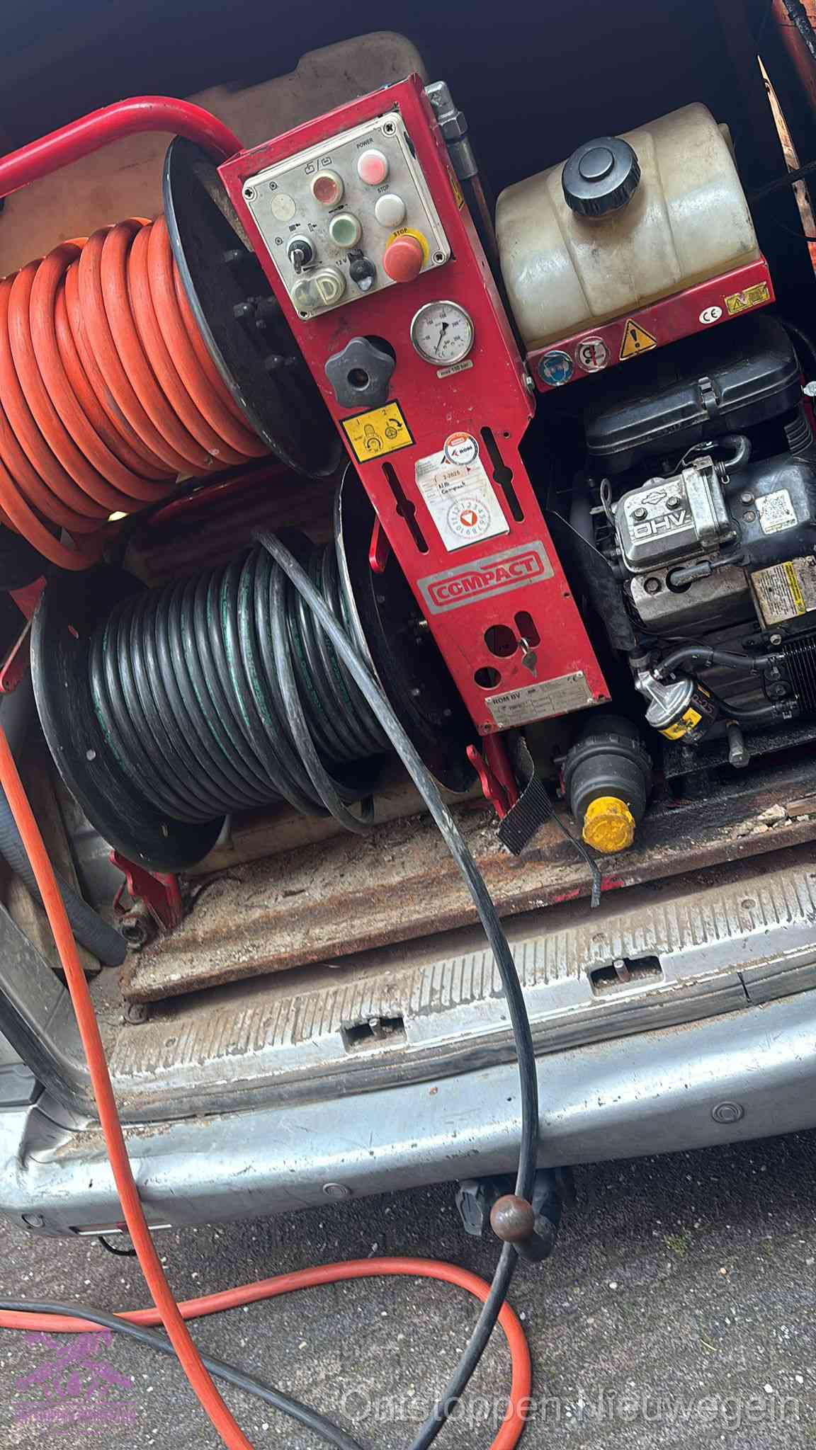 Een rood hogedruk-rioolreinigingstoestel met slangen in de laadbak van de bedrijfsbus, apparatuur voor een hardnekkige wc-verstopping in Nieuwegein