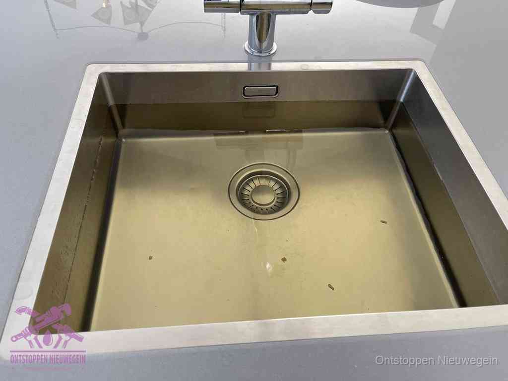 Stilstaand water in een rvs spoelbak dat niet wegloopt, een duidelijk signaal van een gootsteenverstopping in Nieuwegein