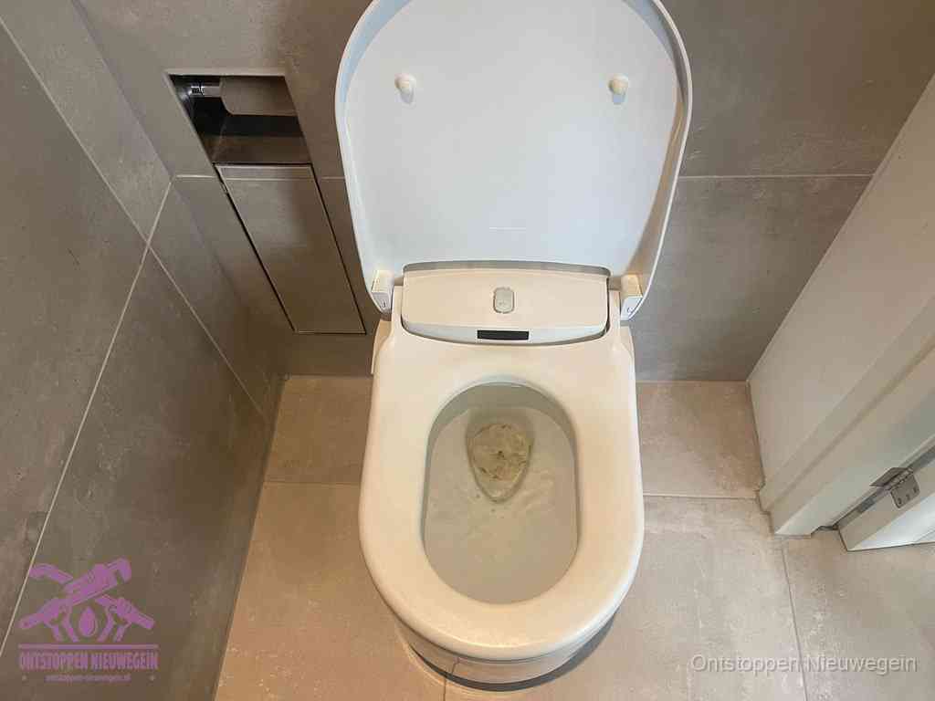 Een wit hangtoilet waarin een prop wc-papier op het water blijft drijven, een duidelijk signaal van een verstopte wc in Nieuwegein