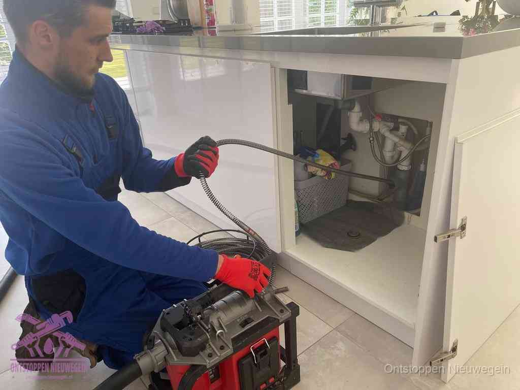 Een monteur reinigt de keukenafvoer grondig met een veermachine om terugkerende gootsteenverstoppingen te voorkomen in Nieuwegein