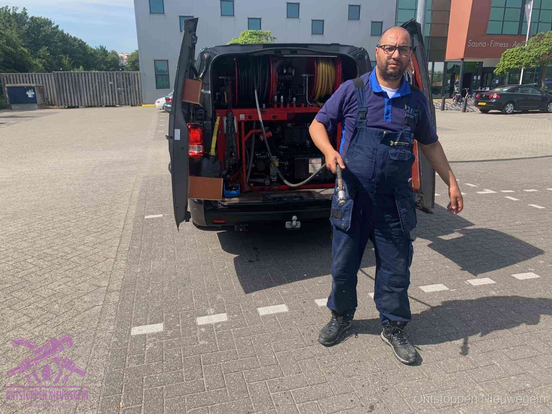 Een monteur bij zijn bestelbus met een hogedruk- en rioolreinigingsunit, klaar om de oorzaak van terugkerende wc-verstoppingen aan te pakken in Nieuwegein