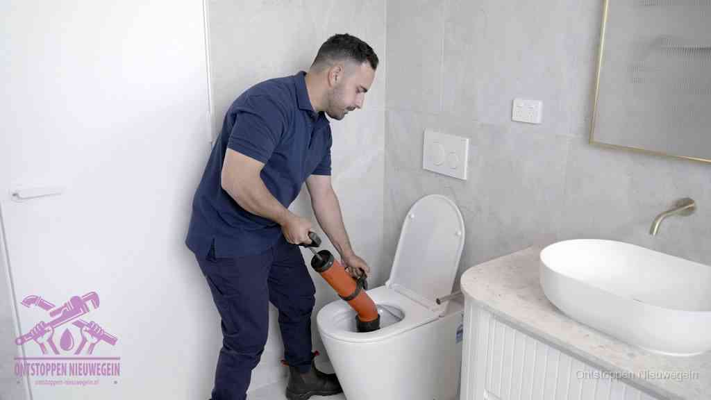 Een monteur gebruikt een handmatige perspomp (toiletontstopper) op een wandcloset tijdens het professioneel wc ontstoppen in Nieuwegein