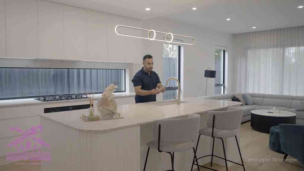 Een bewoner bij de keukenspoelbak die zelf aan de slag gaat met een verstopte gootsteen in Nieuwegein